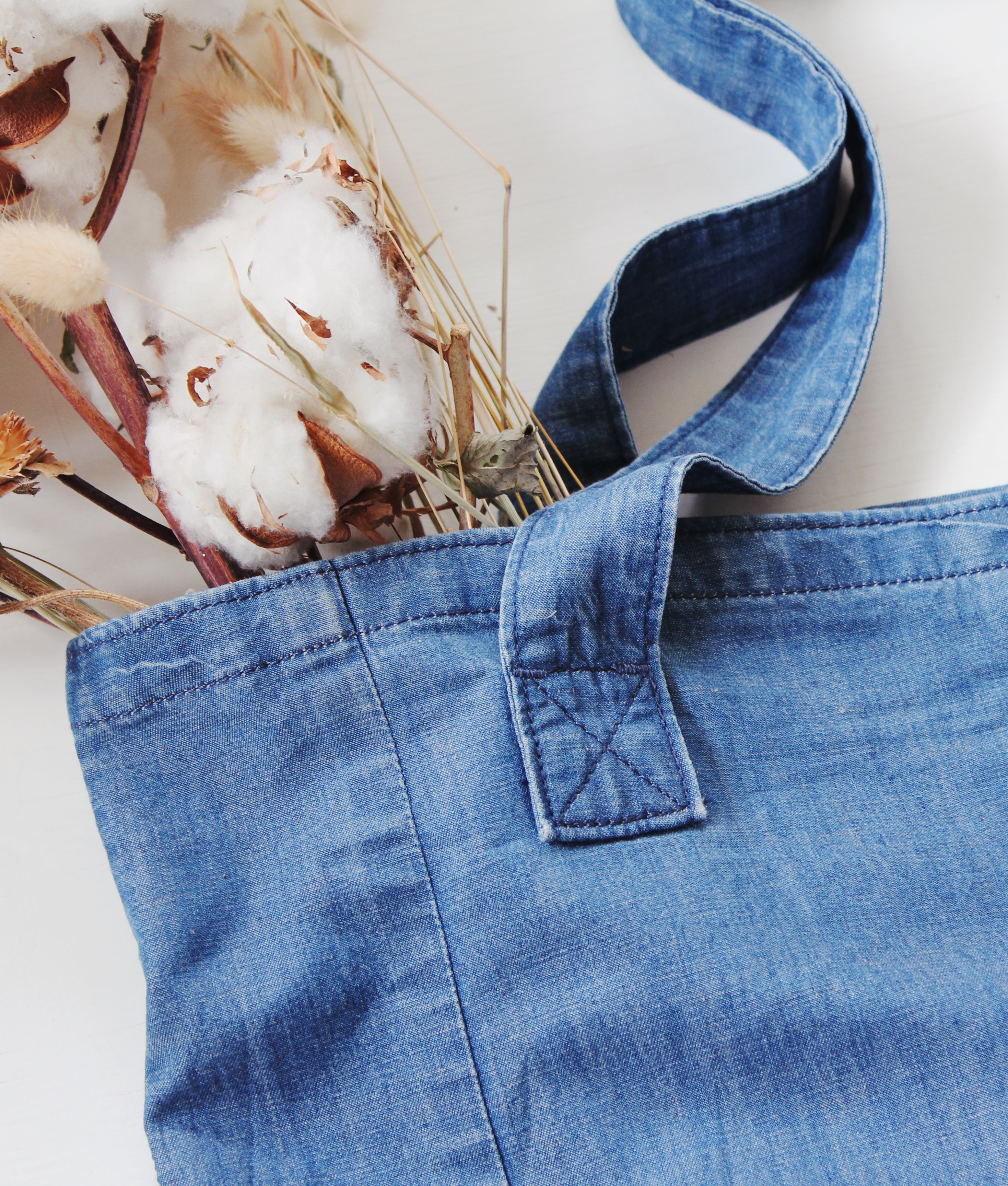 Closeup view of Weekender Denim Tote carrying cotton flowers by Porter Blue Apparel