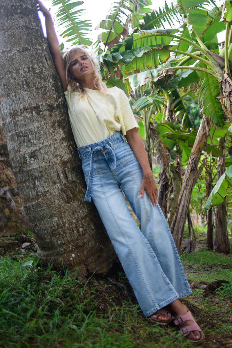 Girl leaning on tree wearing Penny Paperbag Waist in Eden Wash - Eco Friendly Jeans by Porter Blue Apparel