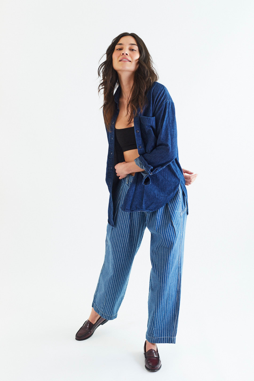 Woman wearing a blue robe and striped pants on a white background