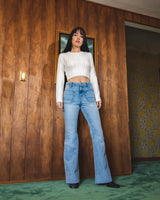Model wearing white shirt and Porter Blue Apparel sustainably made denim Wanderer Flare in Gracie jeans