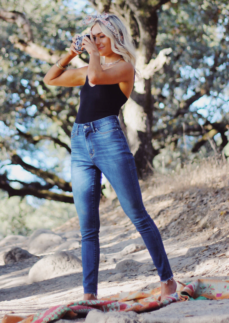 Model taking a photo wearing eco friendly Heart Breaker High Rise Skinny Jeans in Vera Wash by Porter Blue Apparel 