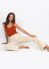 Model sitting on ground wearing The Wanderer Flare Corduroy Jeans in Cream by Porter Blue Apparel - Sustainable Denim