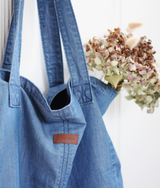 Closeup view of Weekender Ethically Made Denim Tote carrying cotton flowers by Porter Blue Apparel